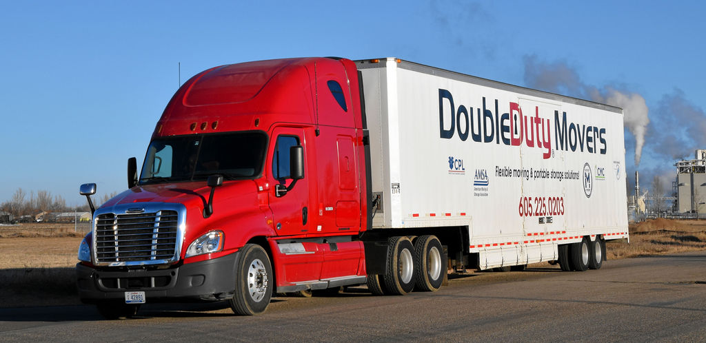 A red and white truck is driving down the street