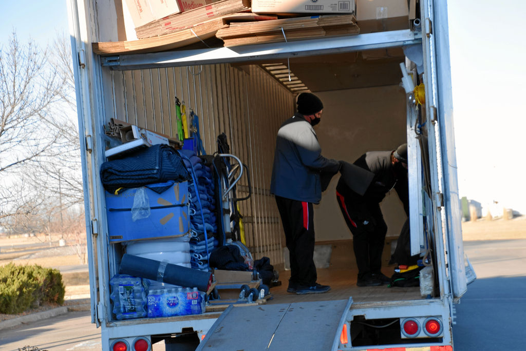 A man standing in the back of a moving truck.