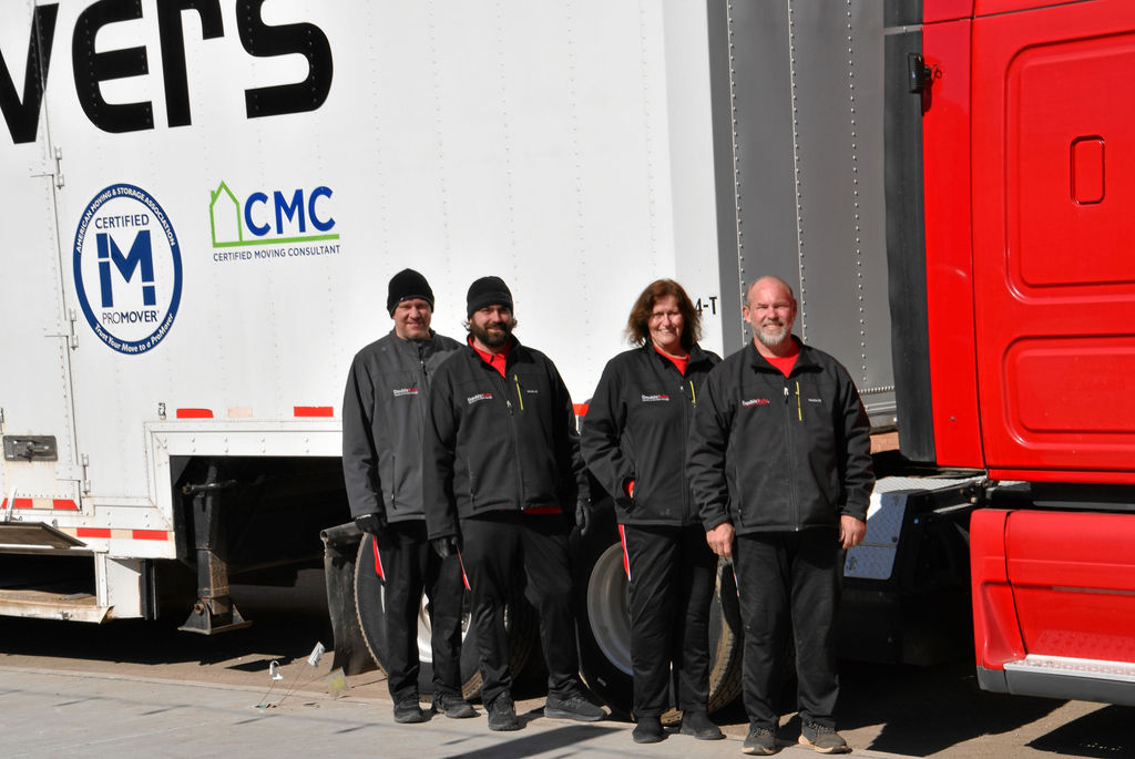 A group of people standing in front of a truck.