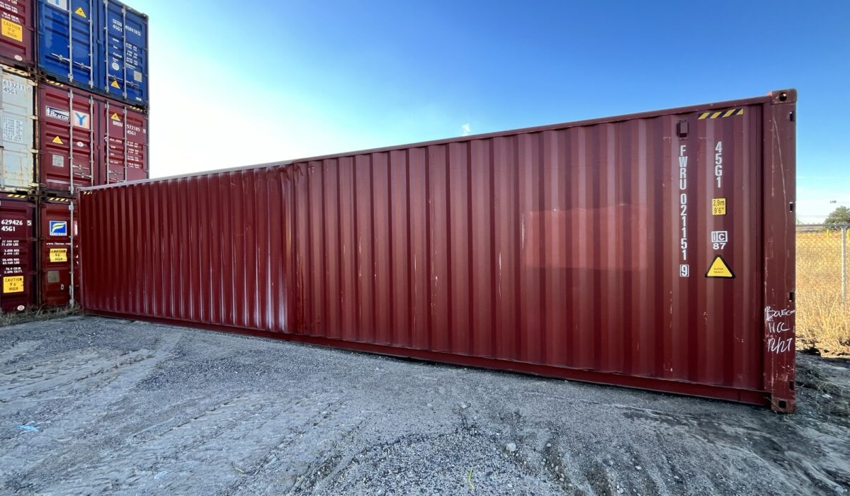 A red container is parked on the side of a road.